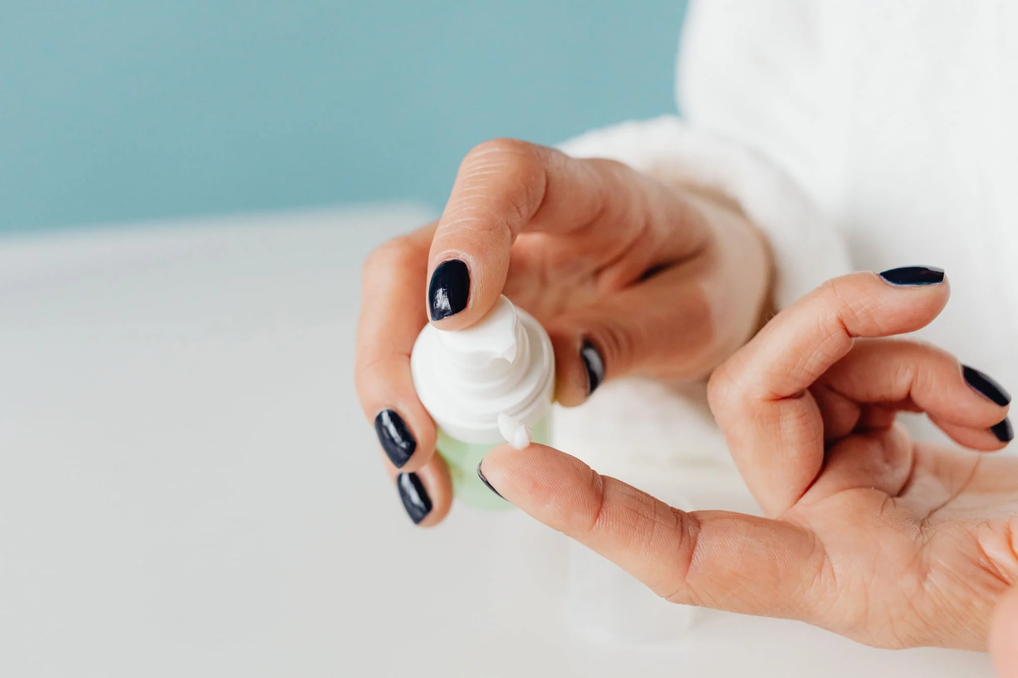 Hands holding a small tube of cream.
